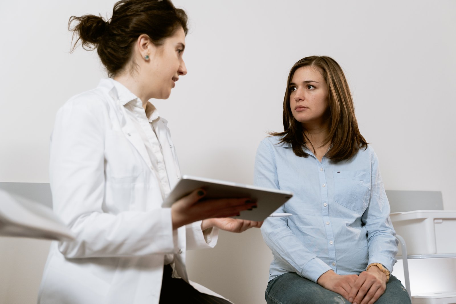 Žena sjedi kod ginekologa i razgovara s njom