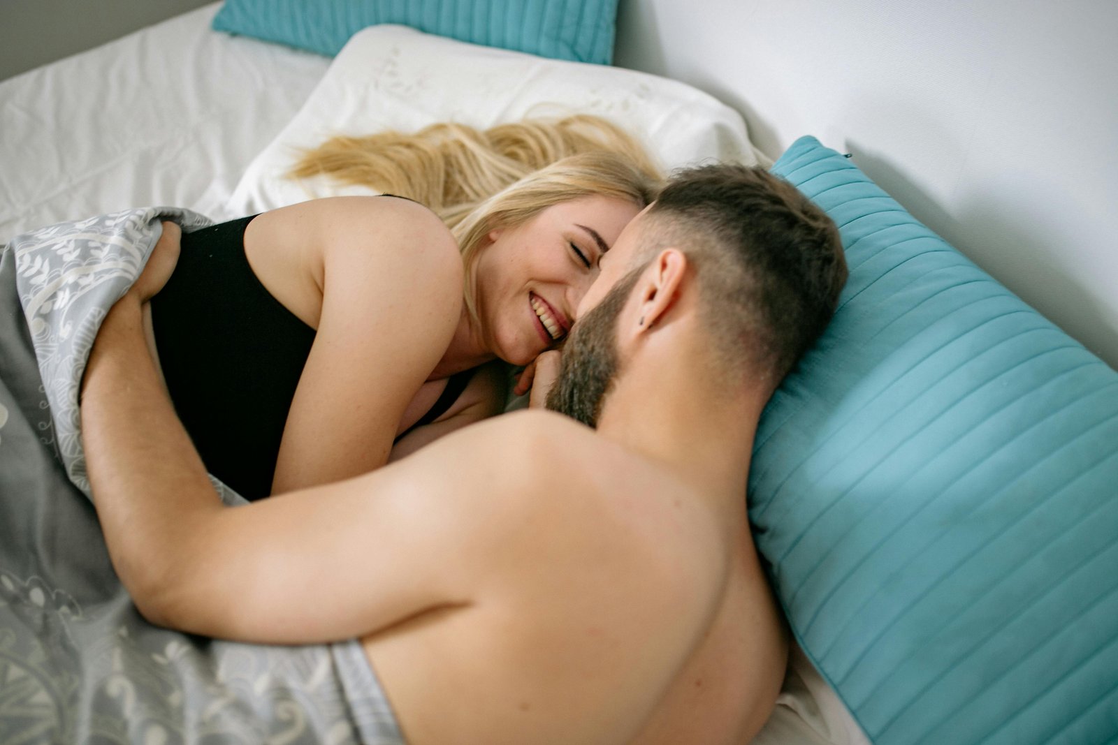 Muškarac i žena maze se u krevetu kao wellness program